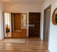The entrance hall in a 3-room apartment with a wooden decor floor and wooden cabinets.