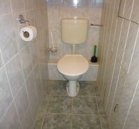 Bathroom with toilet in a 2-room apartment with tiled walls and floor.