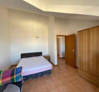 A bedroom in a holiday apartment with a bed, wardrobe, and television.