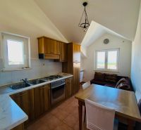 A kitchen with wooden decor, a dining table, and a sofa in a holiday apartment.