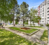 A courtyard full of greenery with benches and a sandbox on Kríková Street, Bratislava - Vrakuňa.