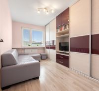 Living room in a 3-room apartment with a wooden decor floor and a corner sofa.