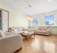 Living room in a 3-room apartment with a sectional sofa and a floor with a wood decor.
