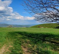 Beautiful green landscape in Budiná with a view of the hills and blue sky.