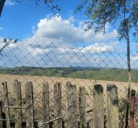 View of fields and hills in Budiná, surrounded by fencing; Land - housing.