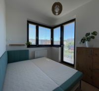 Bedroom in a 2-room apartment with a bed and a wooden dresser, the room is bright.