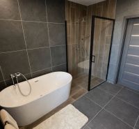 A bathroom in a family house with a freestanding bathtub and a shower enclosure.