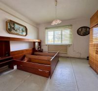 Bedroom in a family house with wooden furniture and a chandelier.