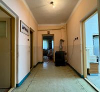 A hallway in a family house with simple lighting and an older interior design.