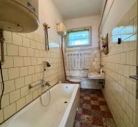Bathroom in a family house with a bathtub, sink, and tiles.