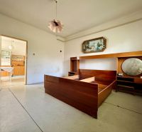 A room in a family house with retro furniture and open doors to the kitchen.