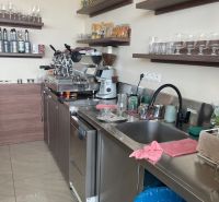 Kitchen space with bar equipment and drinks, floor with wooden decor.