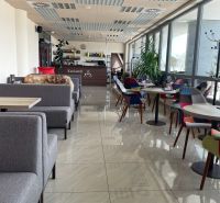 A modern café interior with comfortable seating and large windows.