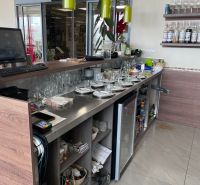 A bar counter with drinks and dishes in a gastro space with a wooden decor floor.