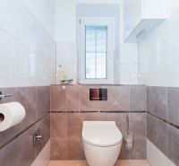 A minimalist bathroom in a family house with tiles and a window.