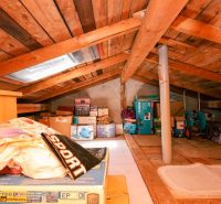 Attic space with stored boxes and wooden paneling in a family house.