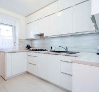 A kitchen unit in a family house with white cabinets and appliances on the countertop.