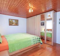 Bedroom in a family house with wood-patterned flooring and a built-in wardrobe.