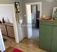 Interior of a family house with a wooden decor floor, a green dresser, and decorations.