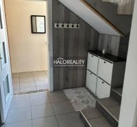 Interior of a family house with stairs, a cabinet, and a coat rack, floor with wooden decor.