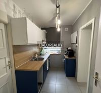 A kitchen in a family house with a wooden decor countertop and light cabinets.