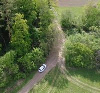 A car on a forest road amidst green vegetation in the Recreational Grounds in Streženice.