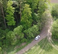 A meadow with a vehicle in front of the forest on recreational land in Streženice, Streženice.