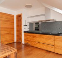A kitchen in a 3-room apartment with a kitchen unit and a floor with a wooden decor.