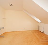 An attic room with a desk and a radiator in a 3-room apartment.