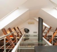 An attic space with a glass floor, an armchair, and air conditioning in a 3-room apartment.