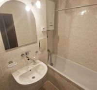 Bathroom with a mirror, sink, and bathtub in a 3-room apartment.