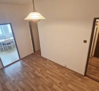 A room with a wooden decor floor, entrance door, and dining area in a 3-room apartment.