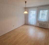 A room in a 3-room apartment with a floor featuring a wooden decor and hanging curtains.