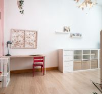 Cozy children's room with wood-patterned flooring, a desk, and storage space.