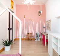Children's room in a 3-room apartment with a pink wall and a floor with a wood decor.