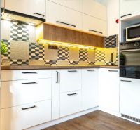 A modern kitchen with geometric tiles and a wooden decor floor in a 3-room apartment.