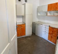 A kitchen in a family house with white and orange cabinets.