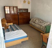 A room with two beds and a cabinet in a family house.