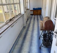 A hallway in a family house with blue tiles and large windows.