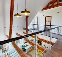 A family house with an open floor plan, steel railing, and wood-patterned flooring.