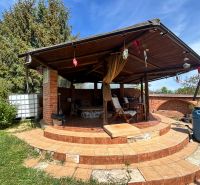 A covered terrace at a family house in Veľké Chlievany with brick cladding and stairs.