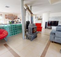 Living room with a fireplace in a family house, modern furniture and a well-lit space.