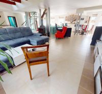 Living room in a family house with a comfortable sofa, fireplace, and dining area.