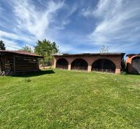 A garden with a shelter and a brick building at a family house in Veľké Chlievany.
