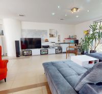 Living room in a family house with a large sofa and a red armchair.
