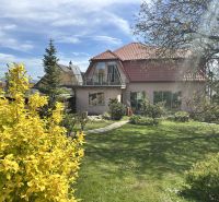 Garden and family house in Veľké Chlievany with a balcony and trees.