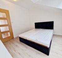 Bedroom with wood-patterned flooring in a 3-room apartment, simple bed.