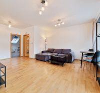 Living room with wood-patterned flooring, a sofa set, and a dining table in a three-room apartment.