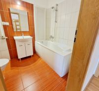Bathroom in a 3-room apartment with a bathtub and a sink, floor with wood decor.