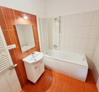 Bathroom in a 3-room apartment with a bathtub and orange tiles.